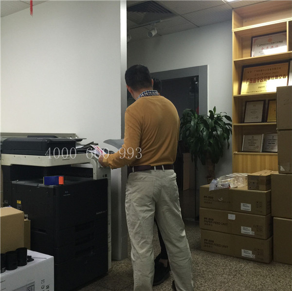 陳先生和蔡師傅在說著柯尼卡美能達C360機器的問題-科頤辦公